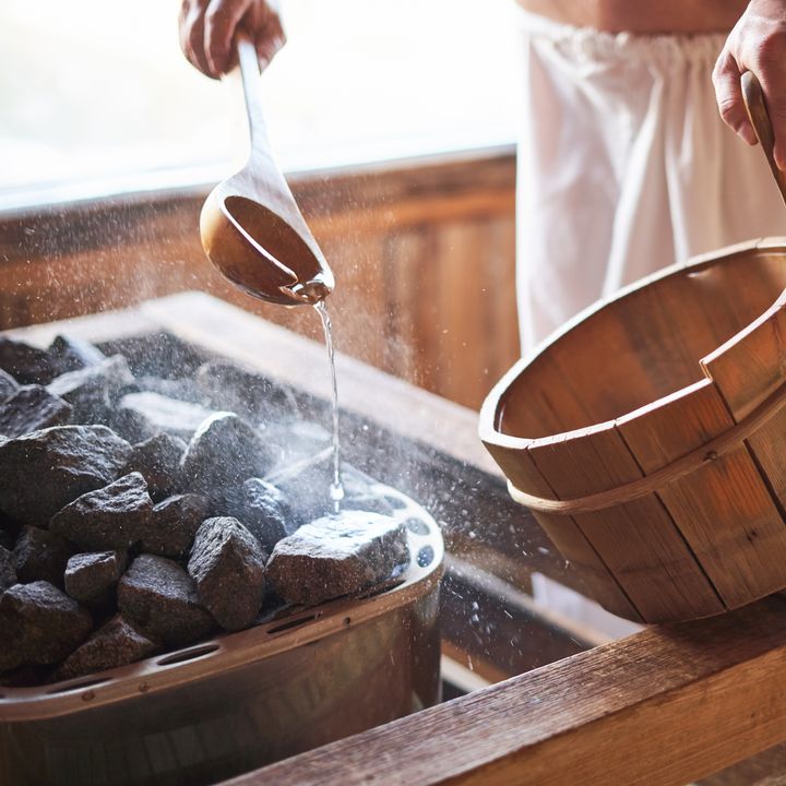 pouring water on hot rocks in sauna