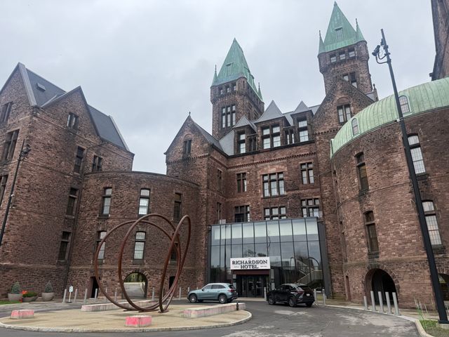 View of the brown brick exterior and circle drive in front of The Richardson hotel in Buffalo