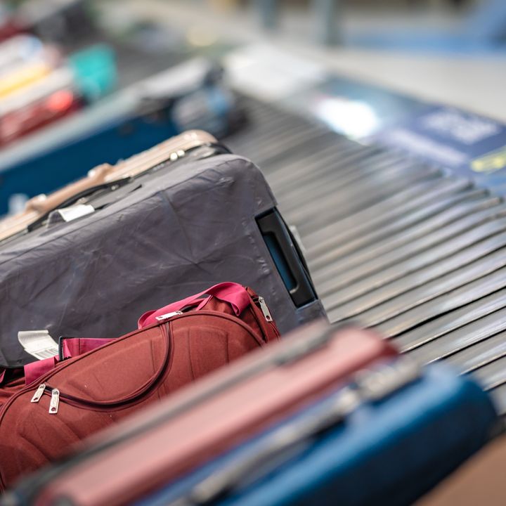 Suitcases sitting on a baggage carousel belt.