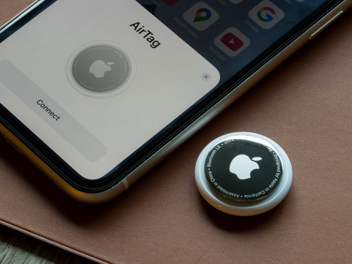 An Apple AirTag is seen being connected to an iPhone.