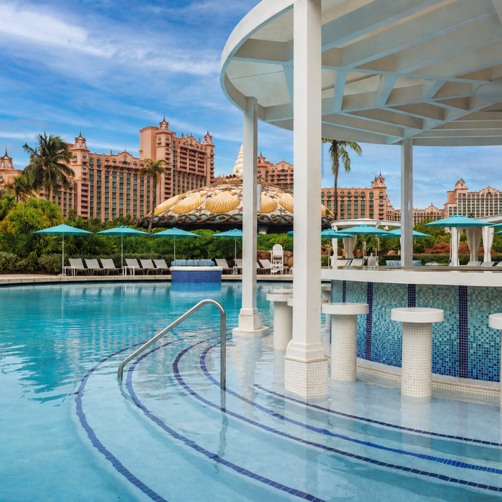 The in-pool Coral Bar at Atlantis Paradise Island with steps in the pool leading up to a circular bar with stools in the pool.