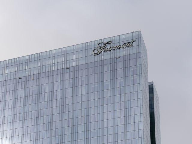 The Fairmont Hotels logo on the outside of a large glass building.
