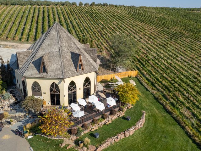 A circular building with a patio overlooking scenic vineyard grounds.