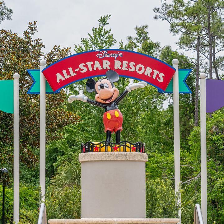 A statue of Mickey underneath a sign for Disney's All-Star Resorts.