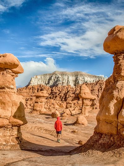A hiker in the middle of hoodoo rocks in Goblin Valley State Park, Utah.
