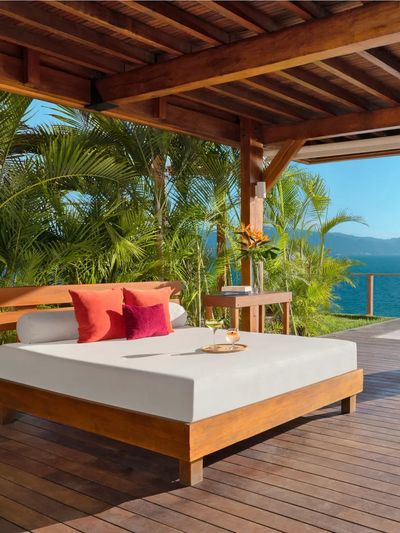 A sunbed, lounge chairs, and infinity pool looking out at the ocean at Dreams Vallarta Bay Resort & Spa.