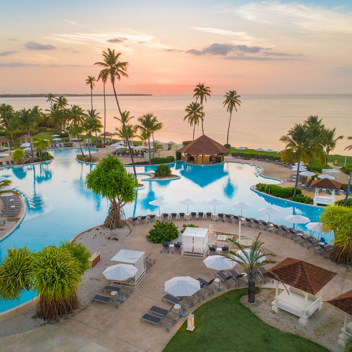 A sprawling lagoon-style pool next to the beach at sunset at the Hyatt Regency Grand Reserve Puerto Rico