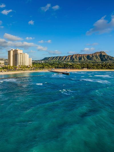 A view of the Waikiki Beach Marriott Resort & Spa as seen from the ocean looking back over the beach and Diamond Head.
