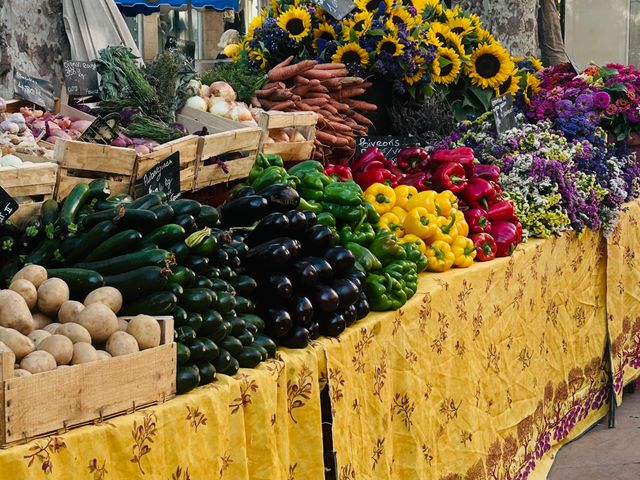 Tables stacked with colorful produce at a flea market.