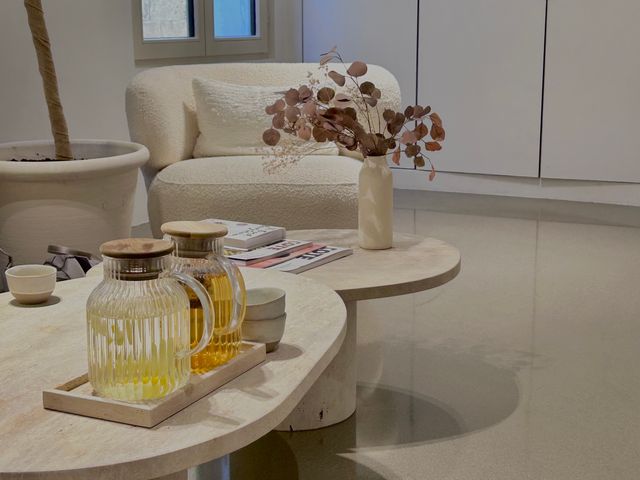 A sophisticated waiting area at a spa with coffee tables arranged with flowers, books, and jugs.