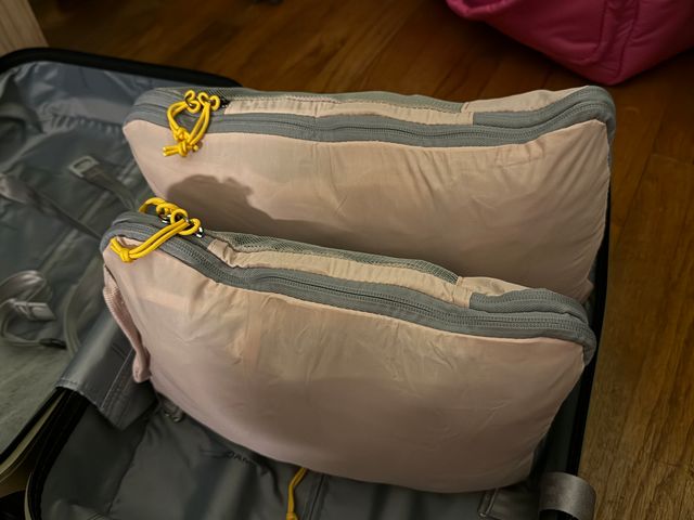 Two full packing cubes turned on their sides inside a suitcase to show that they are fully compressed.