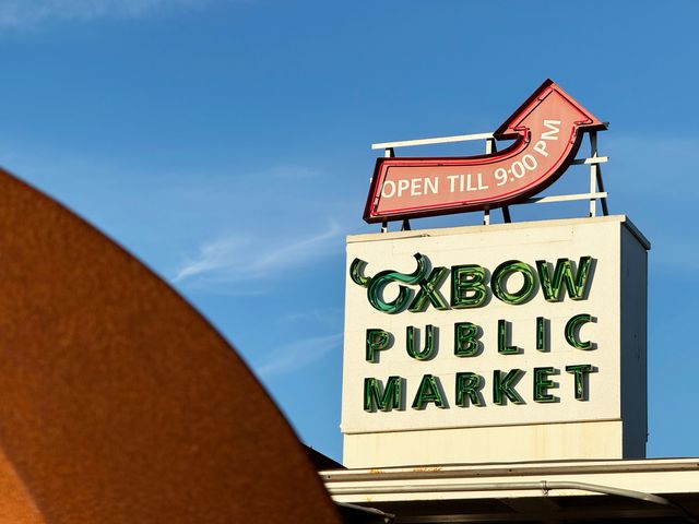 Oxbow Public Market sign with neon text and a red arrow pointing to its 9 PM closing time.