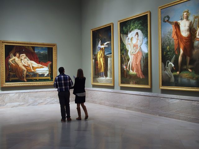 Two people admire framed art inside a gallery room at The Cleveland Museum of Art.