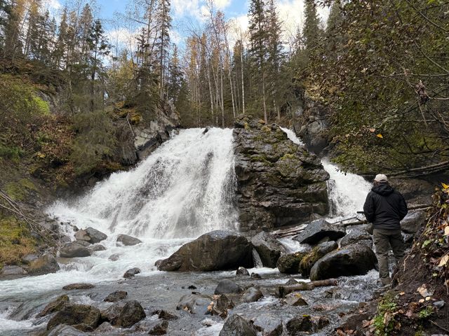 A waterfall cascading over rocks next to trees in Chugach National Forest.