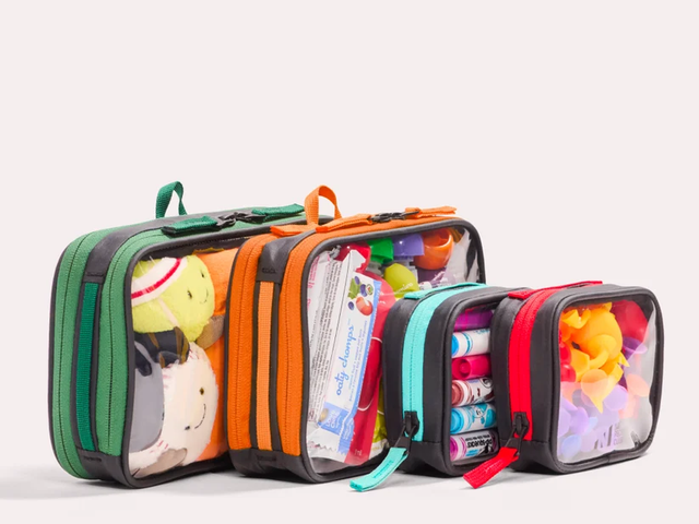 Four translucent packing cubes with colorful trim against a white background.