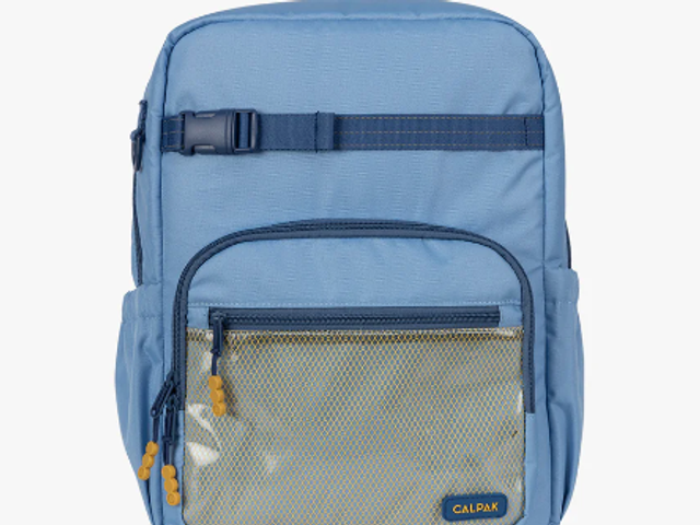 A Calpak kids' backpack in blue against a white background.