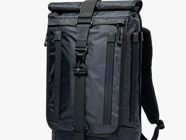 A black roll-top backpack against a white background.