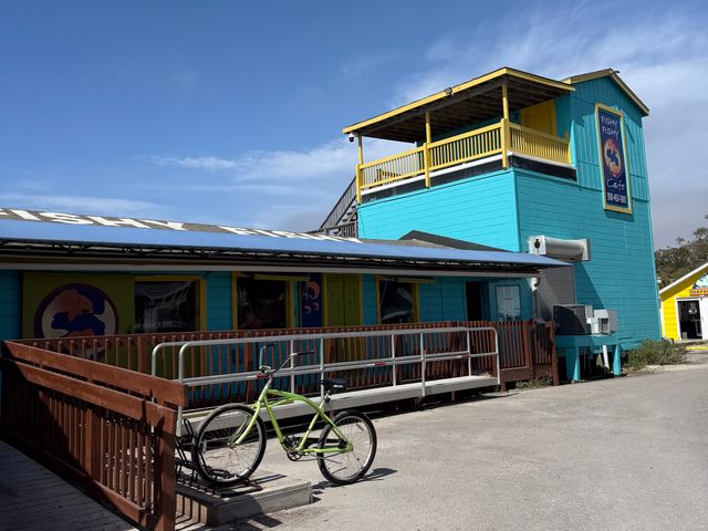 The bright blue and yellow exterior of Fishy Fish Cafe with a bike in front.