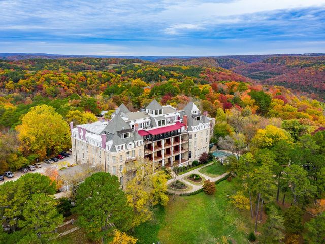 An aerial view over Crescent Hotel & Spa in Eureka Springs, surrounded by trees.