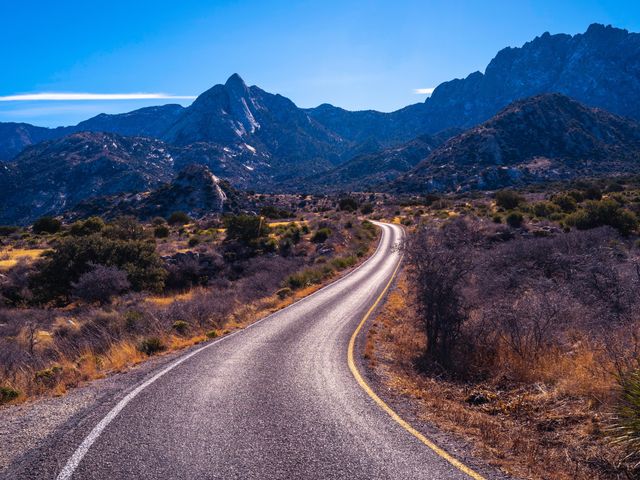 A winding road weaves through a remote stretch of mountains and desert in New Mexico.