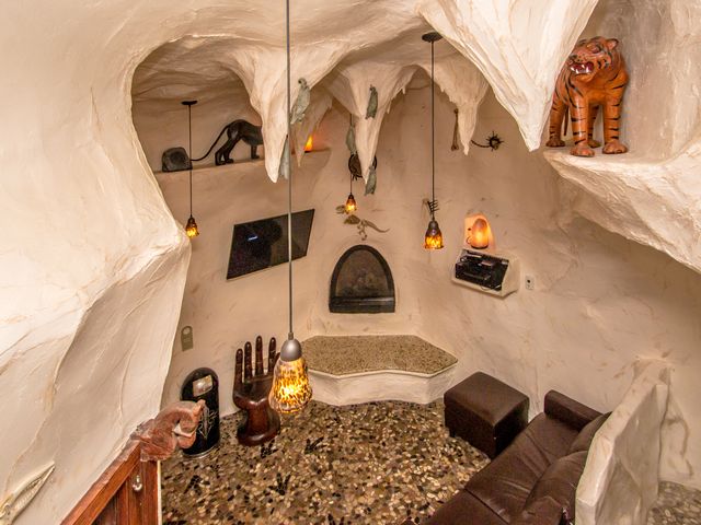 A cave room at Adventure Suites with stone walls, animal art, and a seating area.