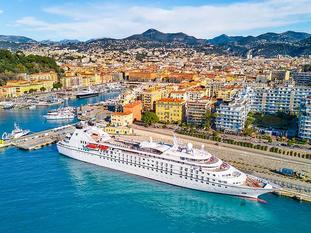 The Windstar Cruises' Star Legend ship in port in the Mediterranear next to a large coastal city.