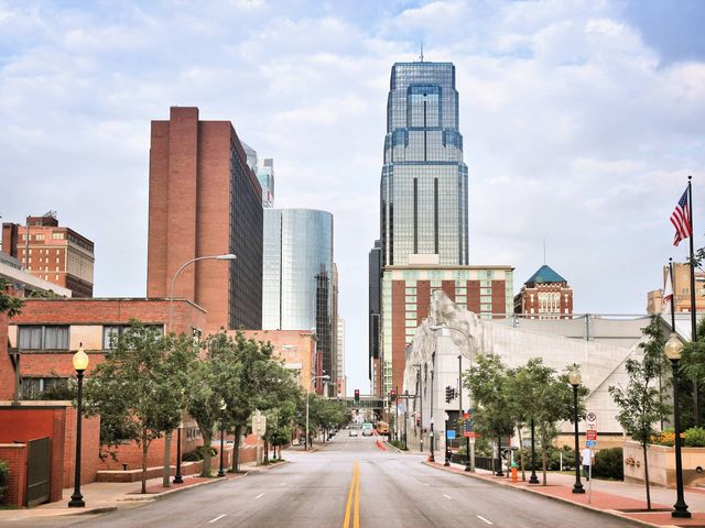 A street in Kansas City with brick buildings and skyscrapers.