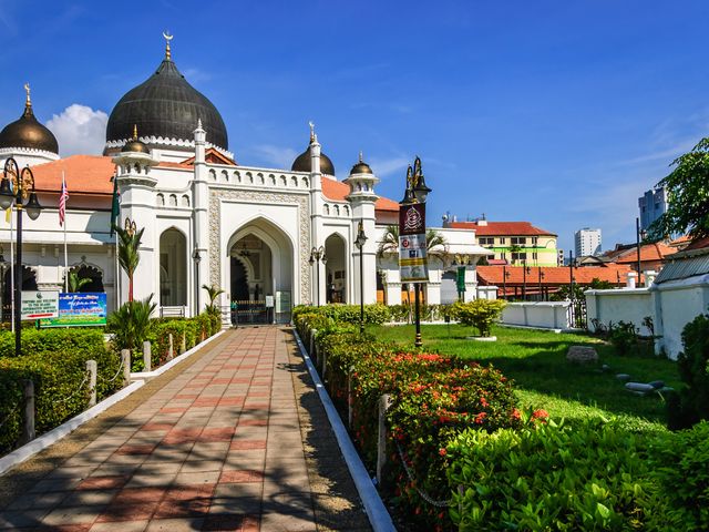 Rows of bushes leading up to a mosque in George Town, Malaysia.