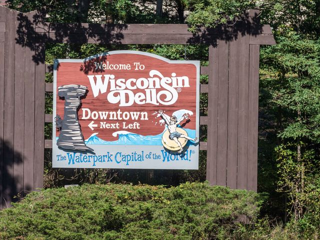 A sign that says, " Welcome to Wisconsin Dells, Downtown next left. The waterpark capital of the world."