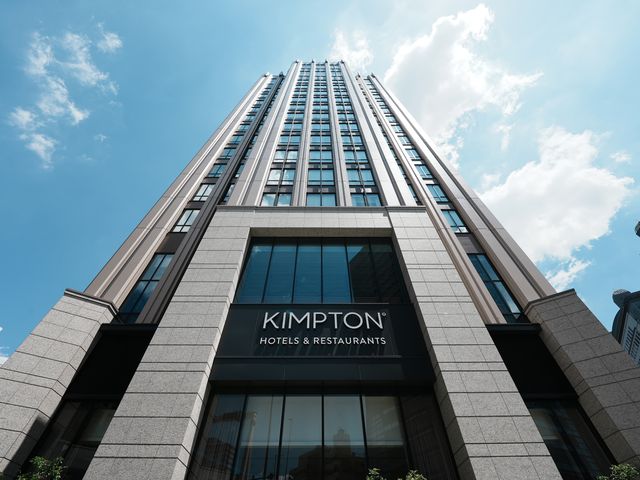 The Kimpton Hotel logo on the outside of a tall building.