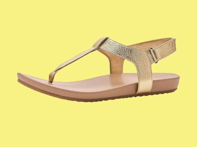 Metallic gold sandals with a thong toe and wrap around ankle  against a white background.