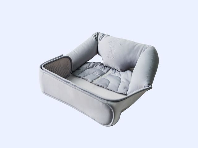 A grey quilted pillow seat against a blue background.
