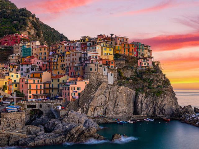 Colorful buildings stacked onto the coastal cliffs of Cinque Terre in Italy.