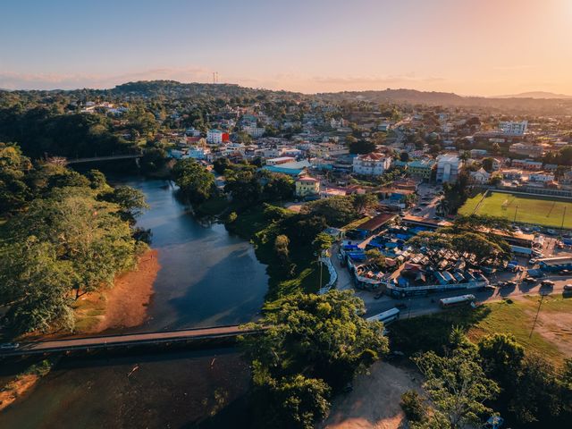 An aerial view over San Ignacio, Belize, with its river and many rooftops at sunset.