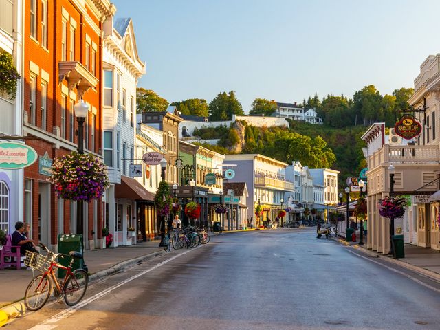 A quaint downtown street with colorful storefronts on either side and no cars.