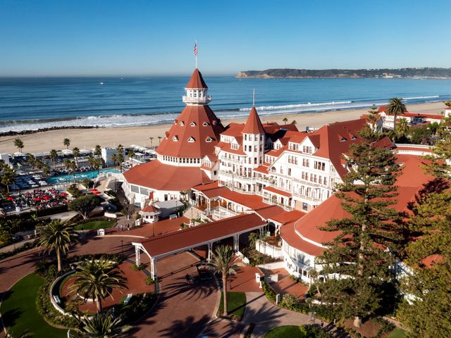 The Victorian Building at Hotel Del Coronado with its red roof and the beach and ocean in the background.
