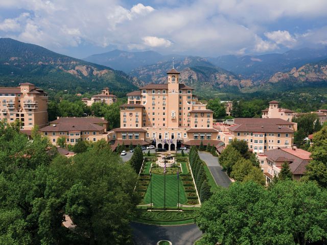 An aerial view of The Broadmoor hotel in Colorado amid majestic mountains.