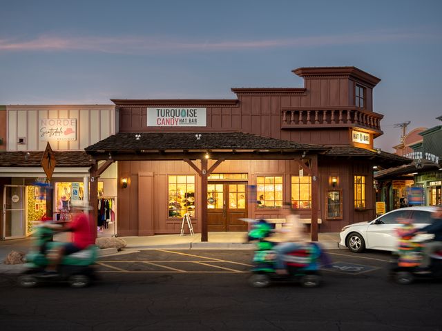 Old West-style buildings in Old Town Scottsdale, with people passing by blurred out.