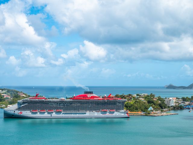 A Virgin Voyages ship is seen docked in Caribbean waters.