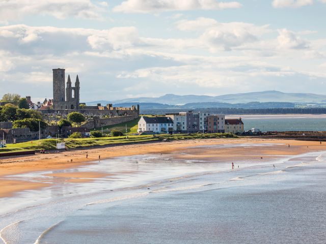 A coastline town with the remains of an ancient castle, plus coastal buildings, and a small beach area