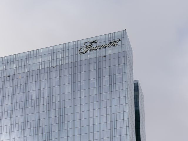The Fairmont Hotels logo on the outside of a large glass building.