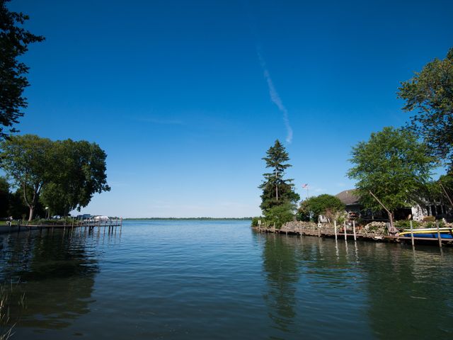 A scenic waterway leading to a large lake with trees and buildings on each side.