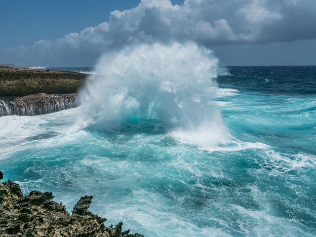 A water blowhole in the ocean spraying water up into the air at Shete Boka National Park.
