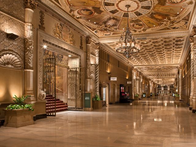 An ornate hotel interior hallway with columns, marble, and statement design accents.