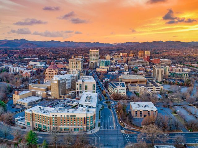 An aerial view via drone over the Asheville skyline at sunset.