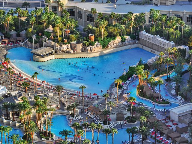 The Mandalay Bay Beach pool complex as seen from above with a sandy wave pool, lazy river, and rows of chairs.