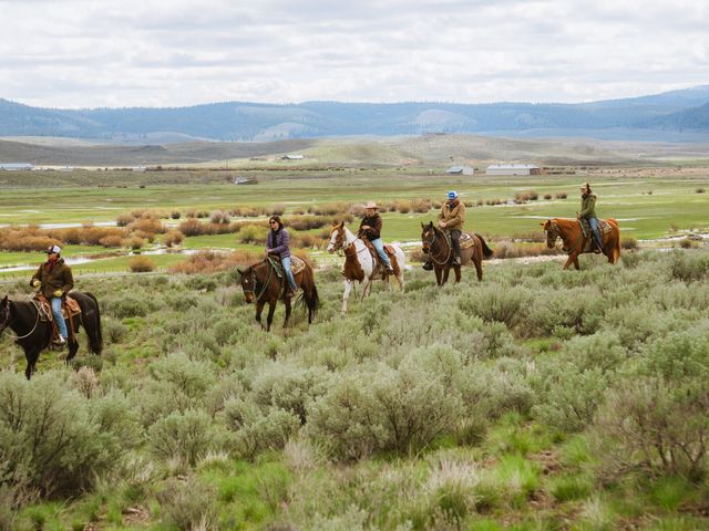 A group of horseback riders in a line in a field.