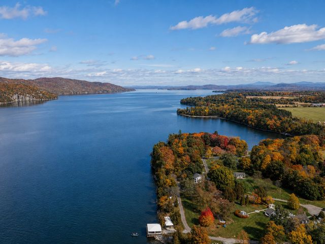 An aerial view over a lake with fall foliage all around.