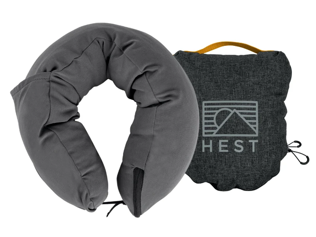 A U-shaped neck pillow next to its case against a white background.