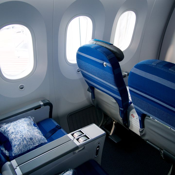 Four premium economy seats inside a plane.